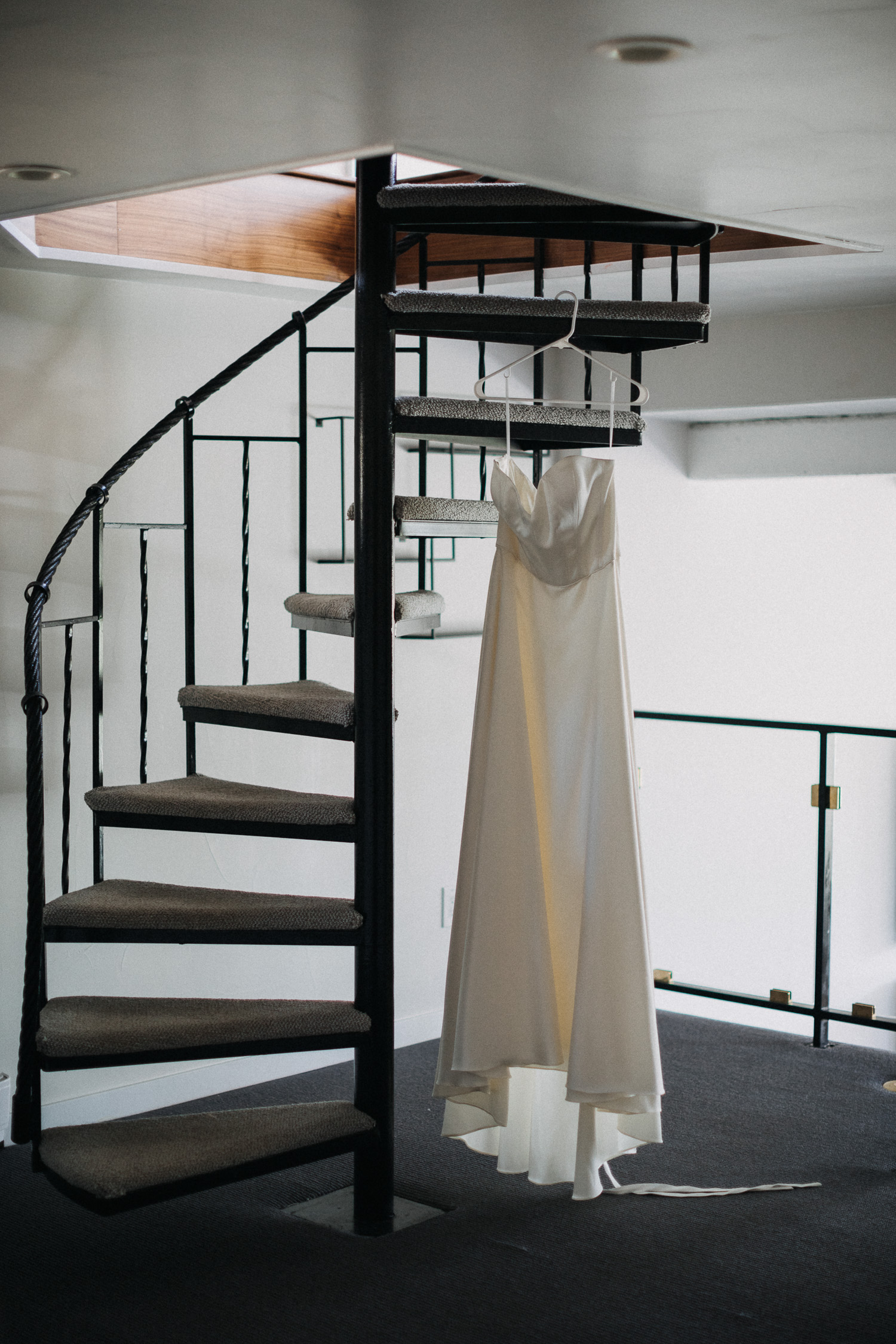 Bridal gown hanging from spiral staircase in the cabin